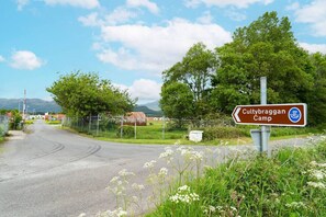 Eine ländliche Straße mit einem Schild für Cultybraggan Camp.