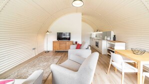 Un espacio habitable compacto con sofá, mesa de comedor y zona de cocina.