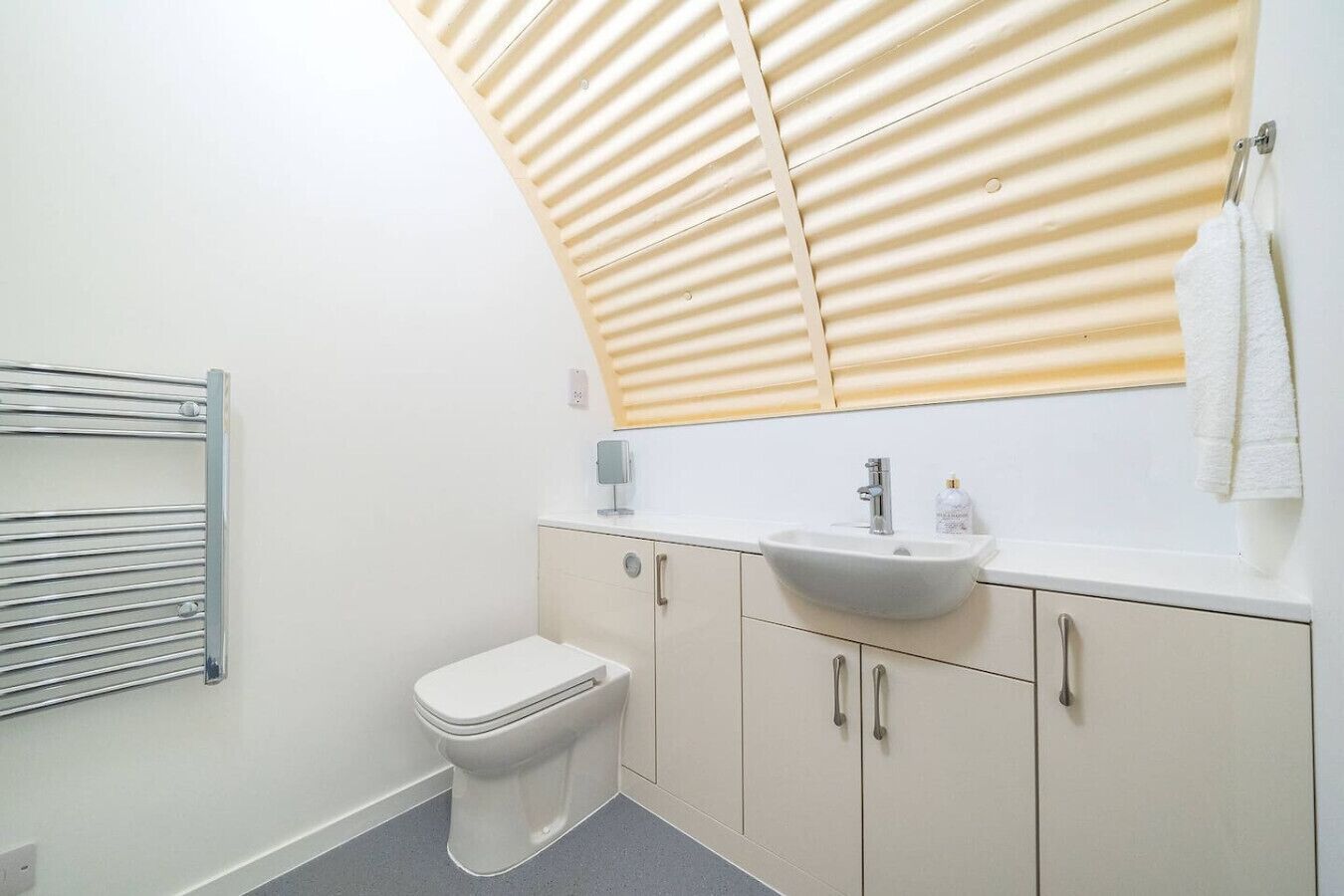 Une salle de bain moderne équipée de toilettes, d’un lavabo et d’un porte-serviettes.