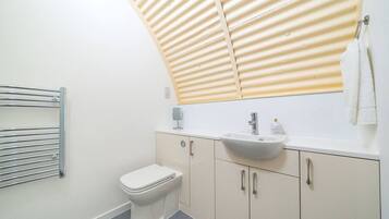 A modern bathroom with a toilet, a sink, and a towel rack.