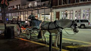 A horse-drawn carriage on a city street at night.