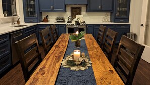 A dining area with a wooden table, chairs, and a blue runner.
