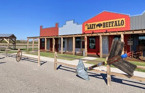 A Western-themed building with a red facade and a sign reading "The Lazy Buffalo."