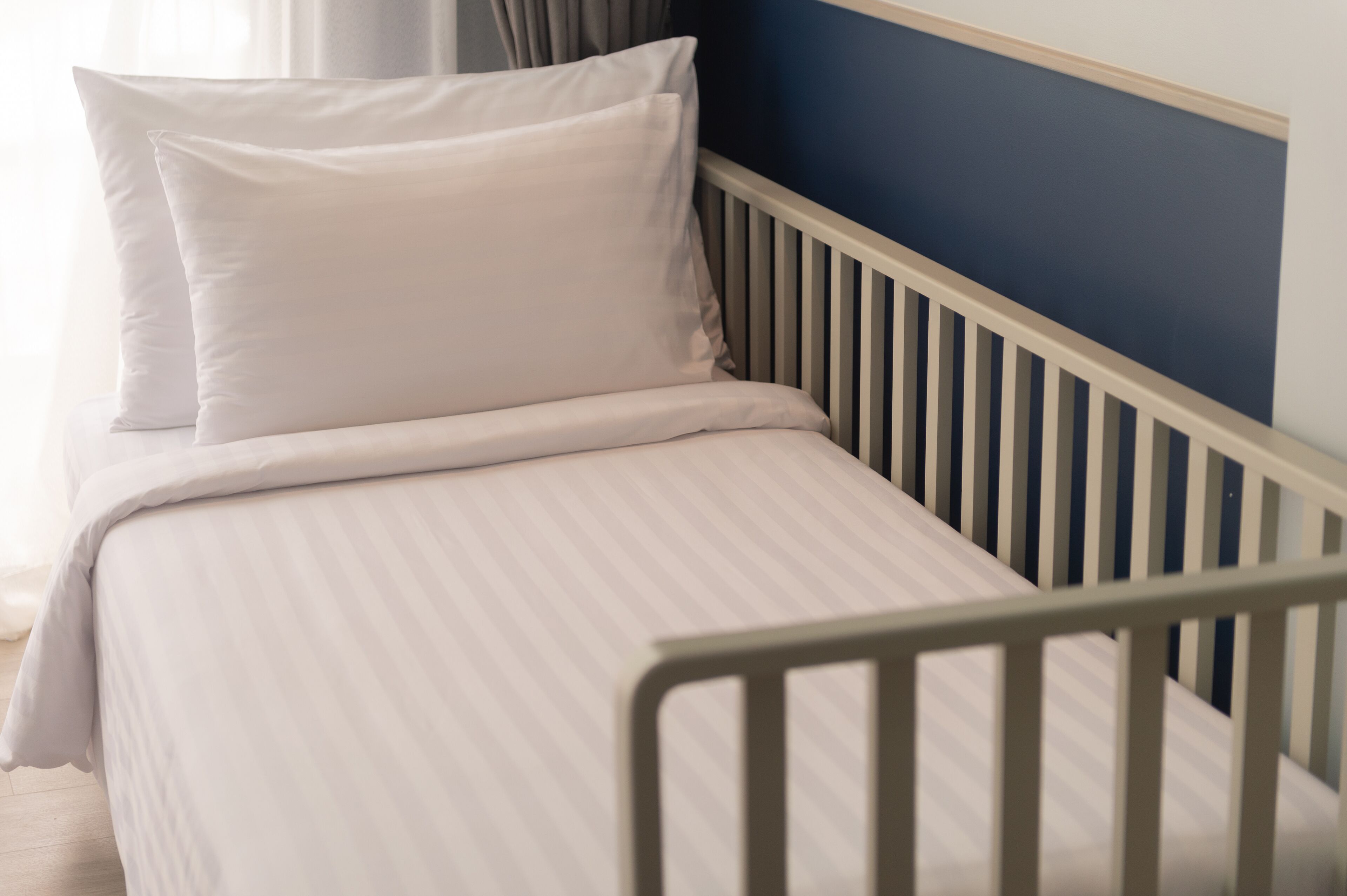 A bed with white bedding and a wooden headboard.