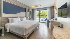 A modern hotel room with a large bed, a desk, and a balcony with a pool view. - Seabed Grand Hotel Phuket (Wichit)