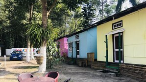 Un pequeño espacio al aire libre con una mesa y sillas, rodeado de edificios coloridos y árboles.