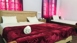 Una habitación de hotel con una cama grande, dos mesitas de noche y un cabecero de madera.