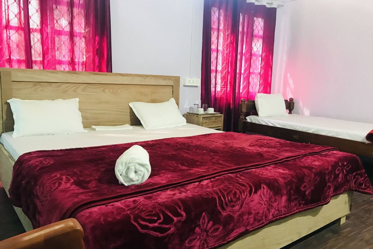 Una habitación de hotel con una cama grande, dos mesitas de noche y un cabecero de madera.