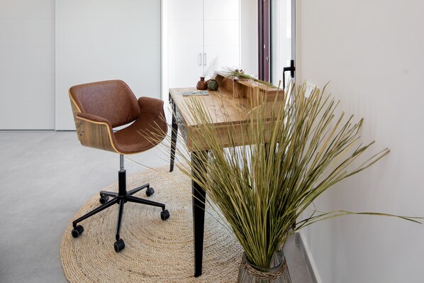 A modern office space with a brown leather chair, a wooden desk, and a large potted plant. - San Juan Denia - Denia, Costa Blanca (Denia)