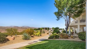 A residential area with a pathway leading to a building with a balcony. - Tuscan Desert Vista #2001 by RedAwning (St. George)