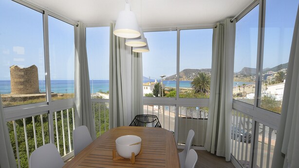 A balcony with a wooden table, white chairs, and a white bowl. - A77 HERNANDO I 3º - G (Calpe)