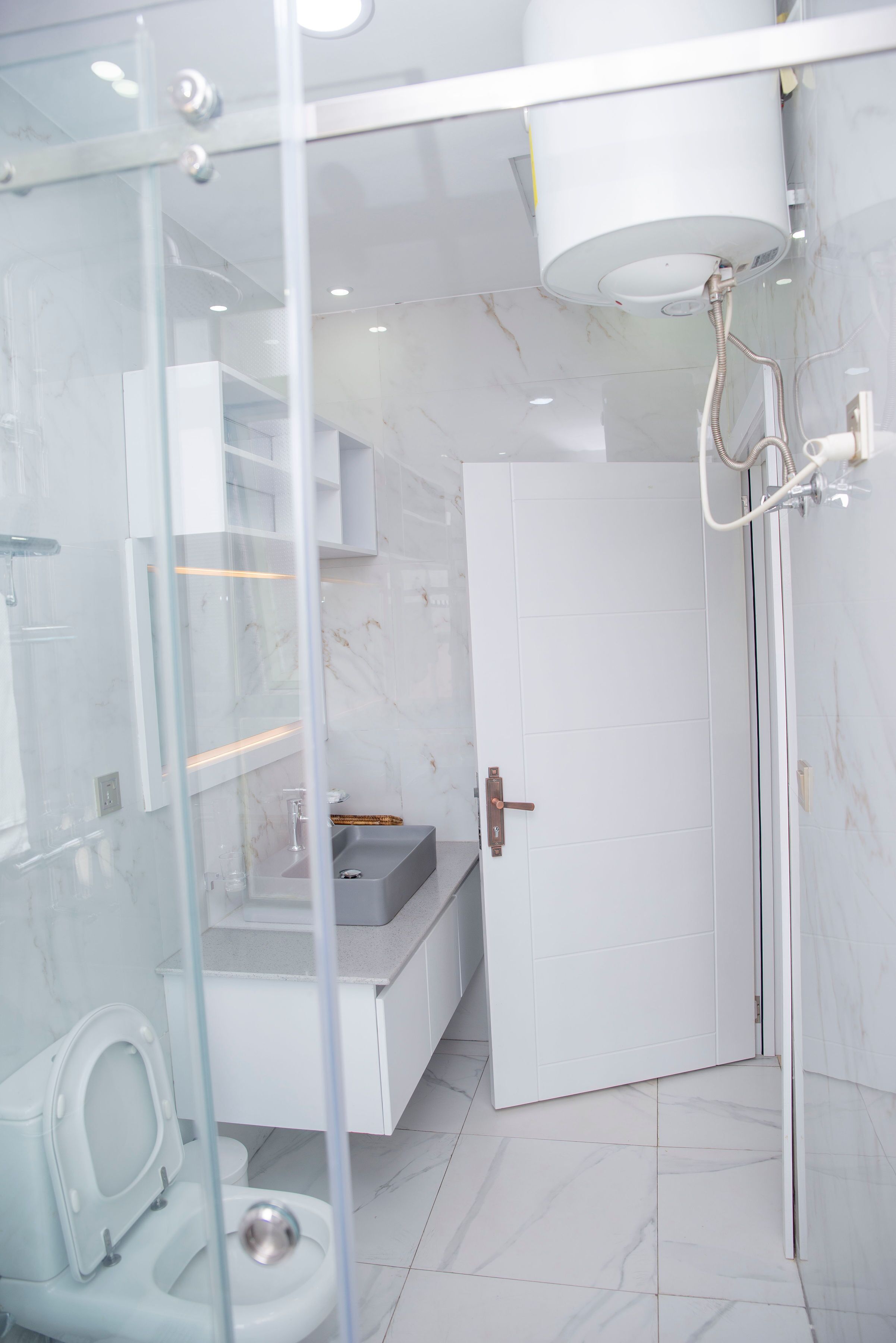 Une salle de bain moderne avec une douche à parois de verre, des toilettes et un meuble-lavabo avec un évier.