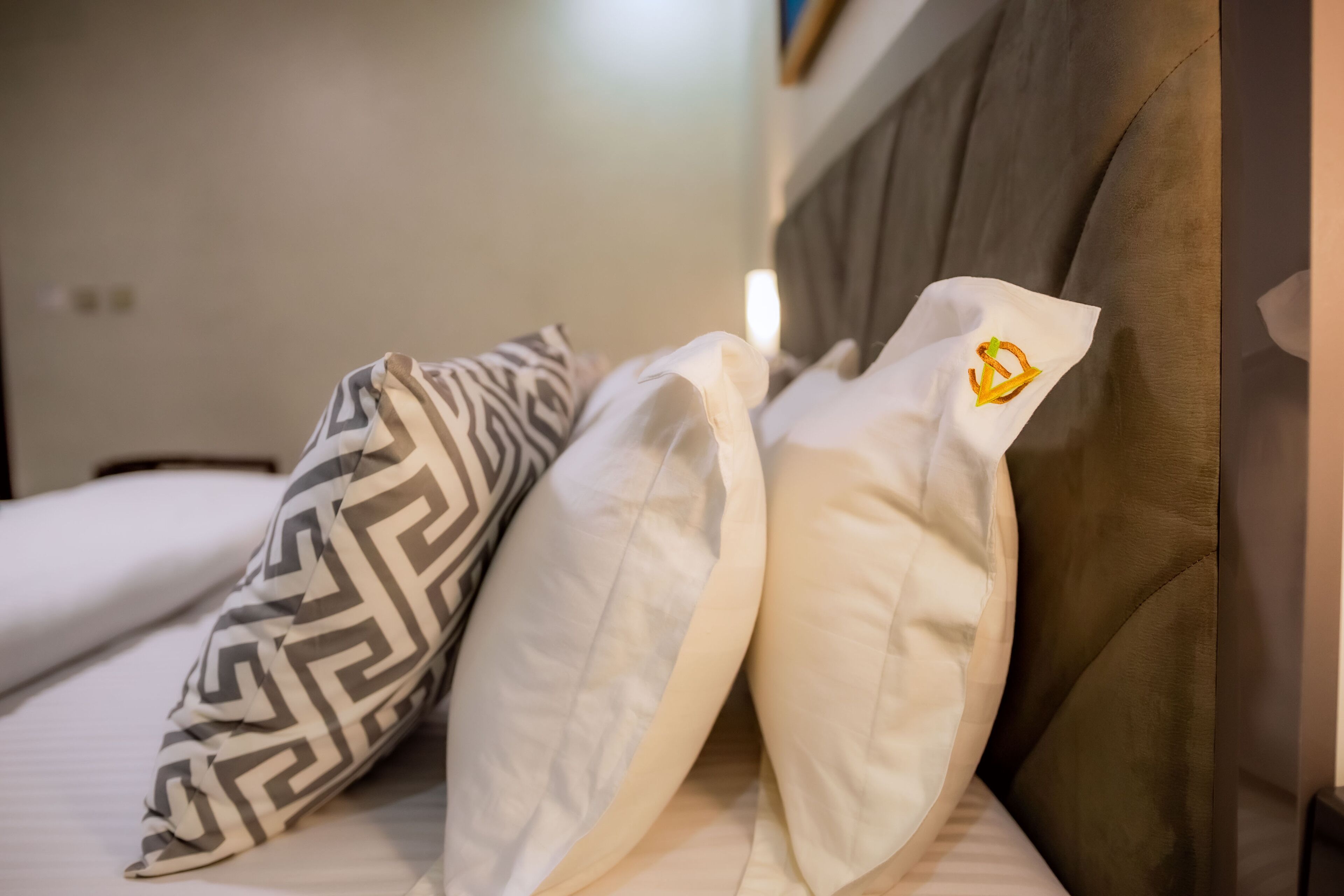 A bed with patterned pillows and a headboard.