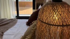 A room with a bed, a hanging woven light fixture, and a view of an outdoor area with umbrellas. - Lagom Hotel Seferihisar (Seferihisar)