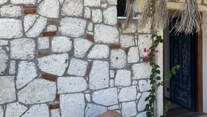 A stone wall with a rustic thatched roof and a large clay pot. - Lagom Hotel Seferihisar (Seferihisar)