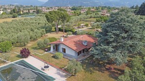 A house with a red roof, surrounded by trees and a garden. - Villa Tamara in San Felice del Benaco (San Felice del Benaco)