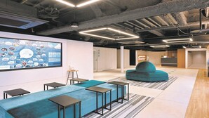 A modern office space with a large display wall, seating area, and exposed ductwork. - Prince Smart Inn Hakata (Fukuoka)