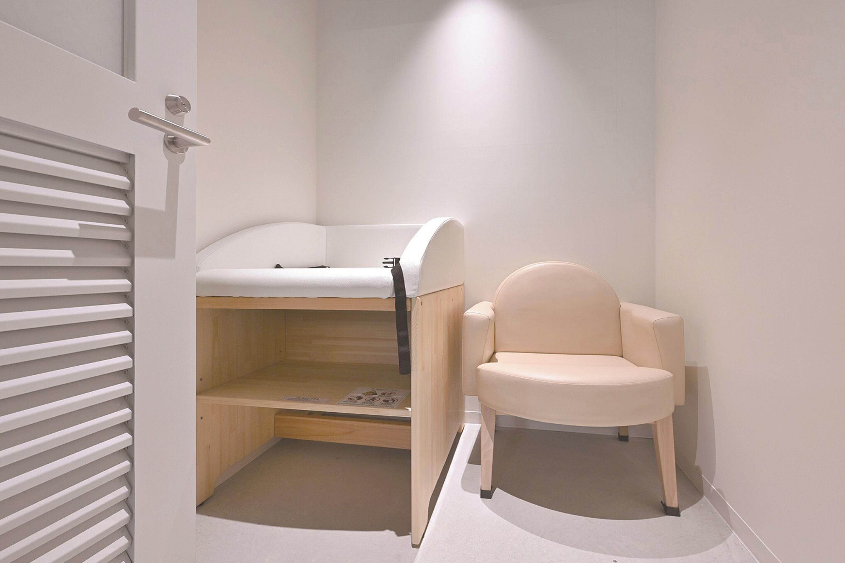 Ein kleines Zimmer mit Etagenbett und einem Sessel.