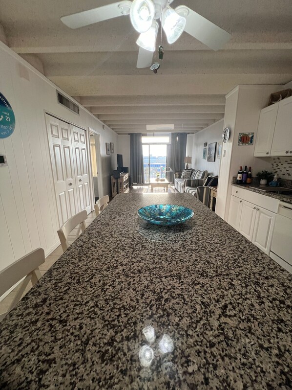 A kitchen with a granite countertop, a blue glass bowl, and a ceiling fan. - Spectacular Oceanside Beach Retreat! Steps to Beach! Pool and Linens Included! (Ocean City)
