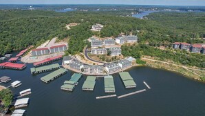 An aerial view of a waterfront property with multiple buildings, docks, and a forested area.