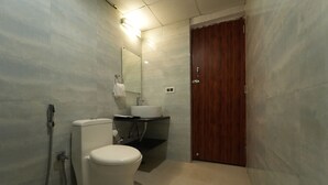 Une salle de bain moderne équipée de toilettes, d’un lavabo et d’une douche.