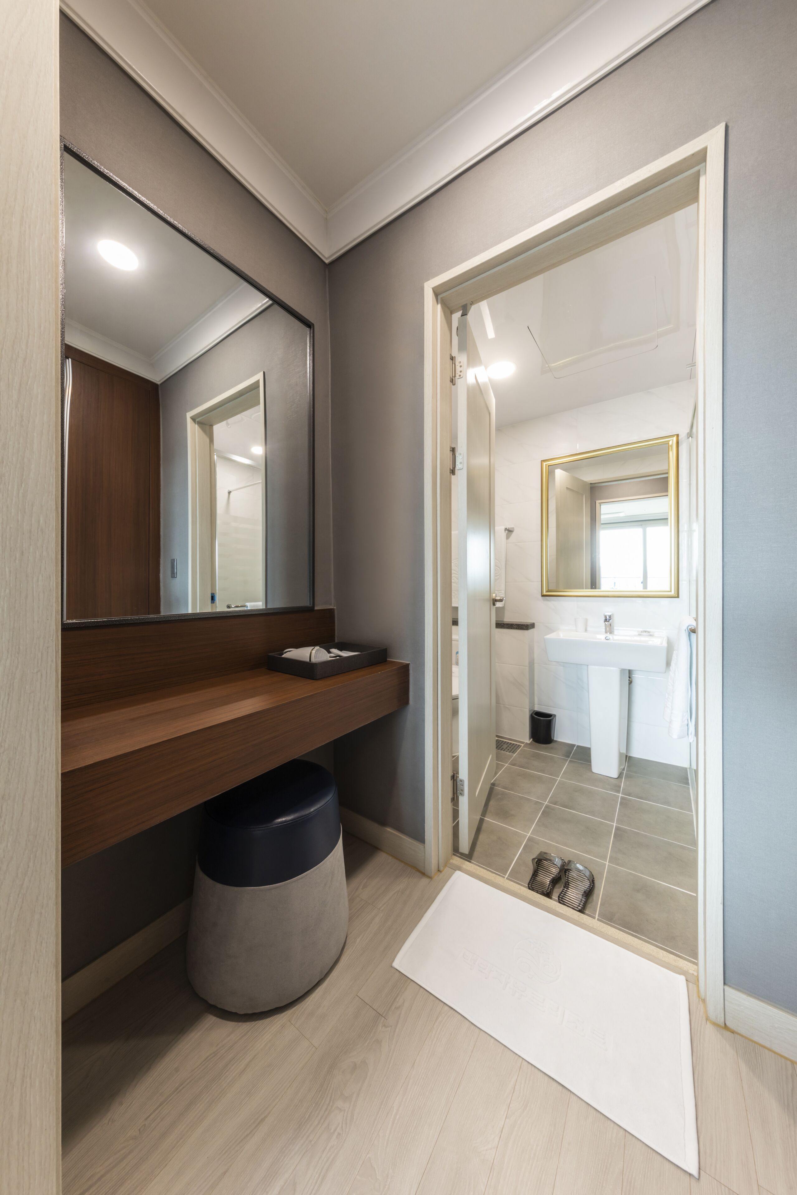 Un baño moderno con tocador de madera, un espejo grande y un lavabo blanco.
