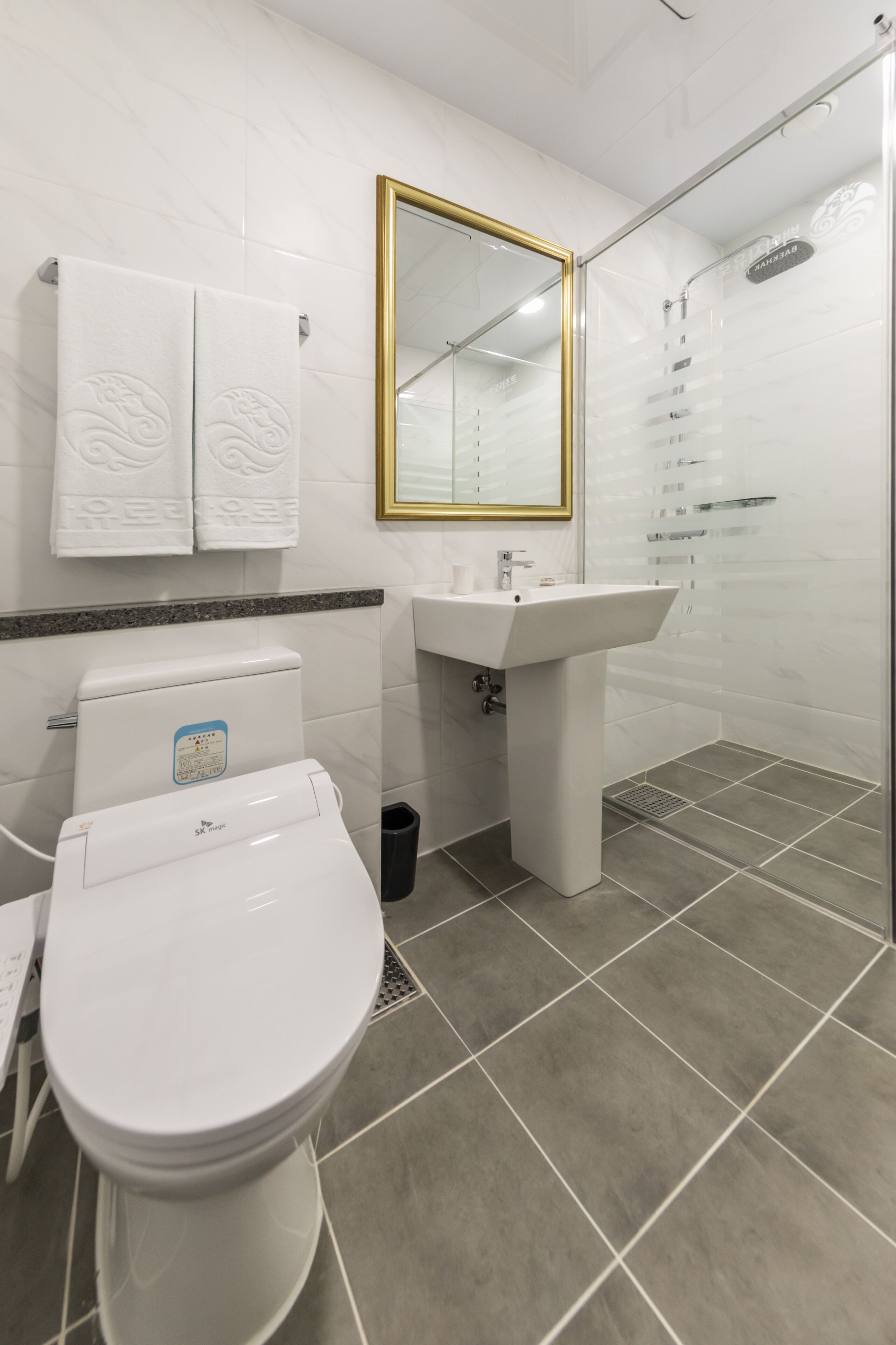 A modern bathroom with a toilet, sink, and shower.