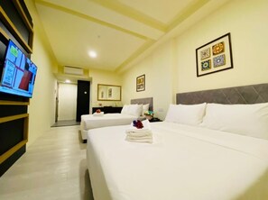 Habitación cuádruple Deluxe | Escritorio y espacio para trabajar con laptop 