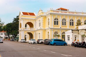 A yellow building with a large archway and a red roof. - BISHOP HOTEL (George Town)