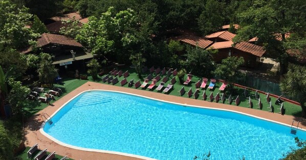 En säsongsöppen utomhuspool, parasoller och solstolar