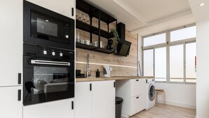 A modern kitchen with a built-in oven, microwave, and a washing machine. - Nala Apartment, Wifi, Algarve !new! (Faro)