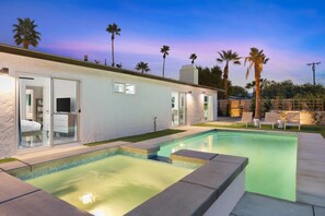 Une maison moderne dotée d’une piscine, d’un patio couvert et d’un garage.