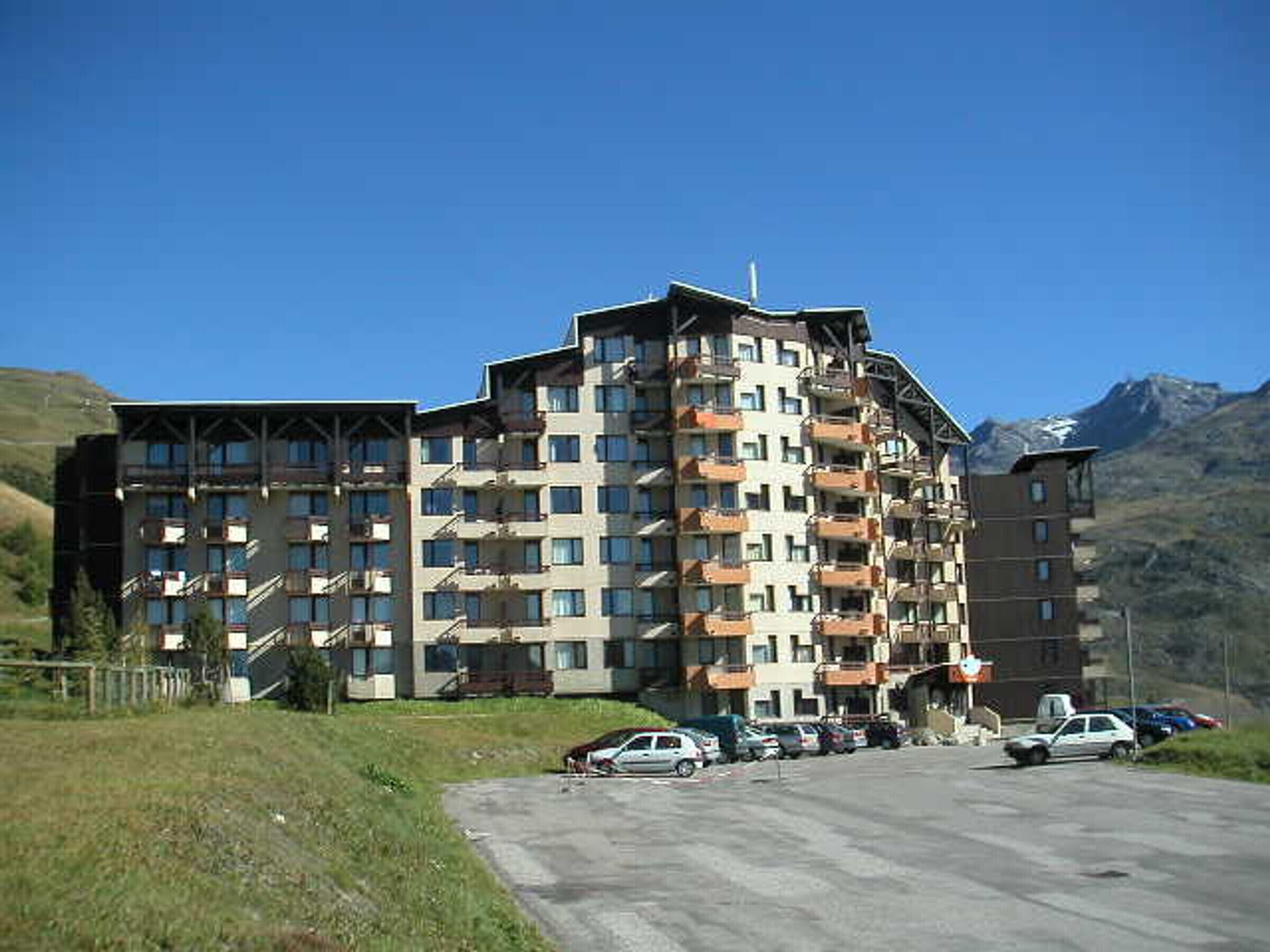 Un hôtel à plusieurs étages doté de balcons, d’un parking et situé dans un cadre montagneux.