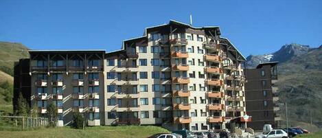 Un hôtel à plusieurs étages doté de balcons, d’un parking et situé dans un cadre montagneux.