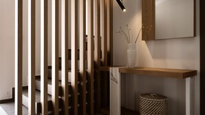 A modern interior with a wooden partition, a white vase with plants, a woven basket, and a minimalist design. - Anthis Luxury Villa (Zakynthos)