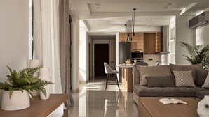 A modern living room with a sofa, coffee table, and a dining area with chairs. - Anthis Luxury Villa (Zakynthos)