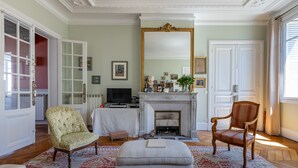 Una sala de estar con chimenea, televisor y un espejo grande.