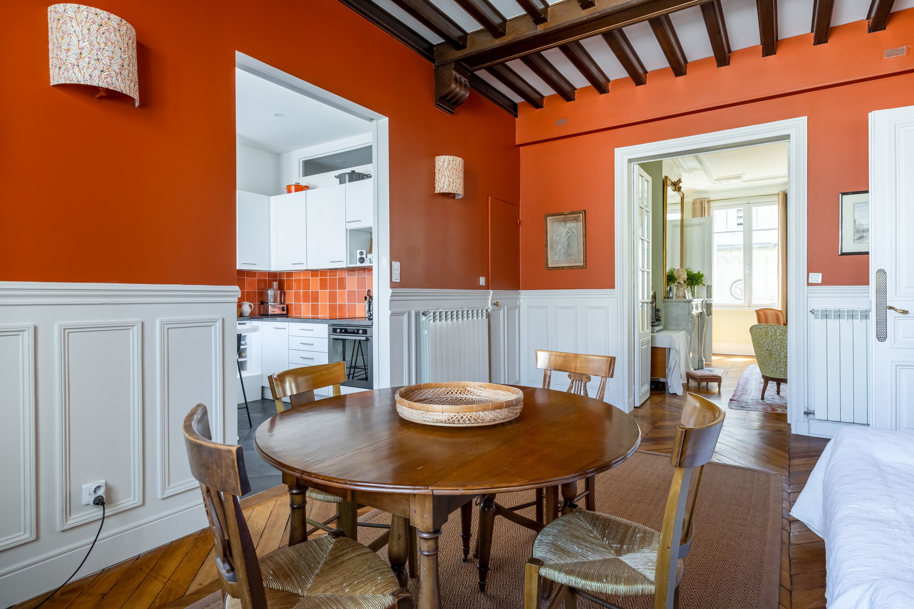 Un coin repas comprenant une table ronde en bois, quatre chaises et un panier en osier.