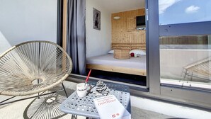 A small, compact room with a bed, a window, and a table with a book and a cup. - Modern 3-room apartment, ski-in/ski-out, balcony, exceptional view (Les Menuires)