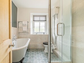 A bathroom with a bathtub, toilet, and glass shower enclosure.