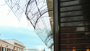 A street view with a building featuring a balcony and a metal fence. - hotel Concordia s.n.c. (Crotone)