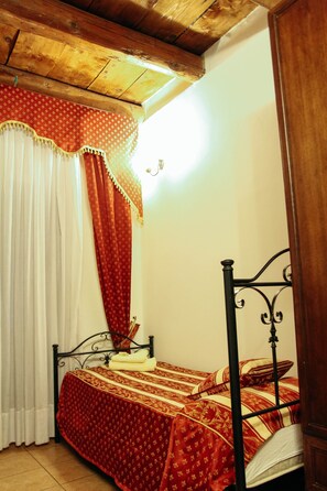 A room with a bed, wooden ceiling, and curtains. - hotel Concordia s.n.c. (Crotone)