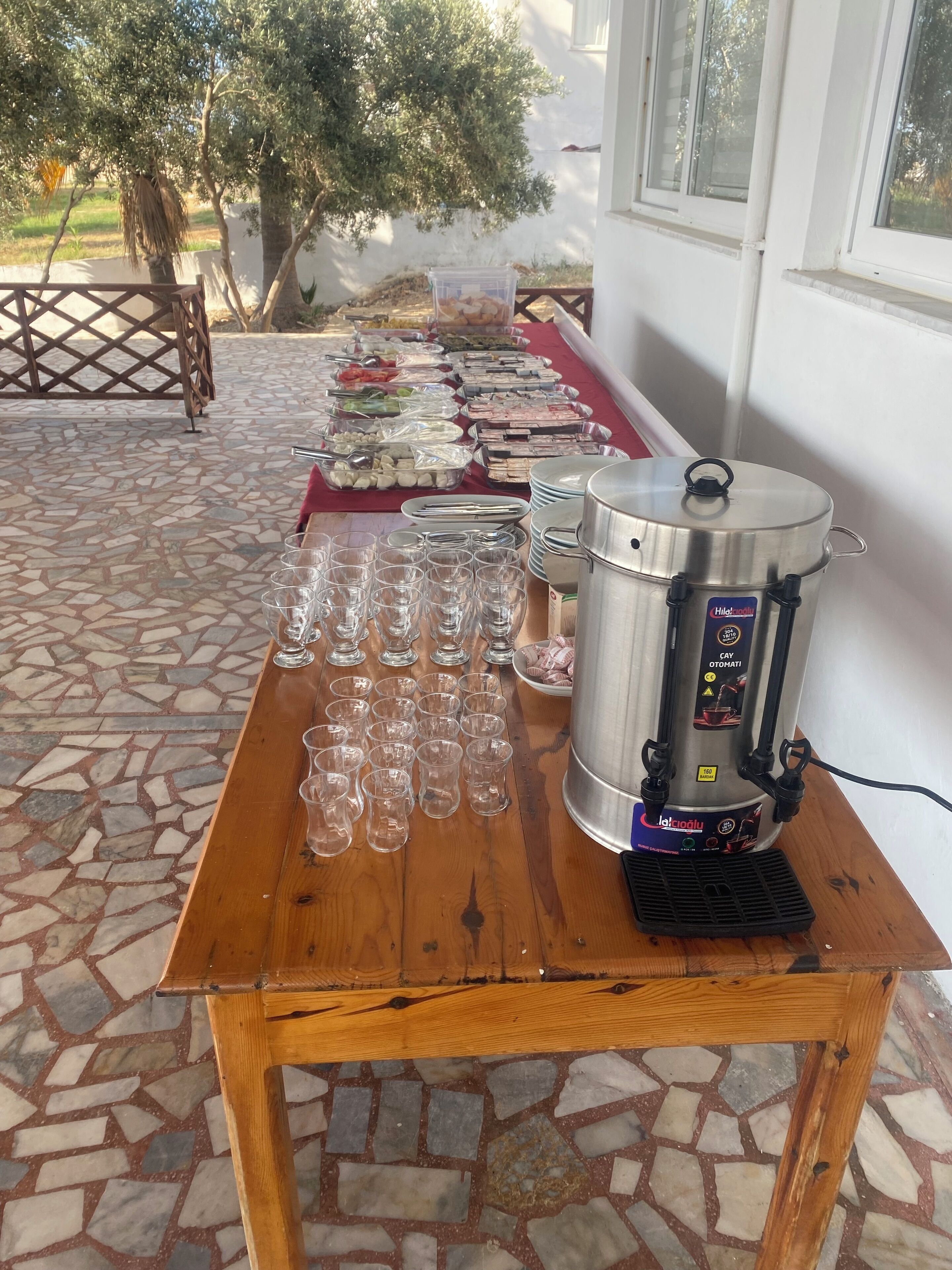 A buffet table with various food items and a beverage dispenser.