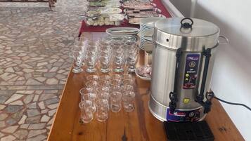 Una mesa de buffet con diferentes alimentos y un dispensador de bebidas.