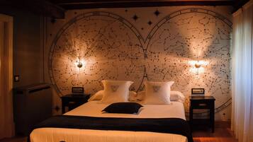 Un dormitorio con una cama grande, dos mesitas de noche y una pared con un mapa estelar.