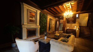 A cozy living room with a fireplace, comfortable seating, and a chandelier. - Casona De La Pinta (Cartes)