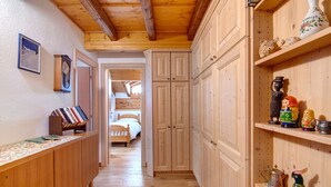 Een hal met houten kasten, een bed en een plank met decoratieve objecten.