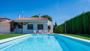A swimming pool with a white house in the background.