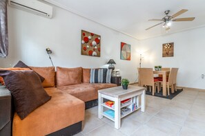 Una sala de estar con sofá, mesa de centro y un comedor con sillas y mesa.