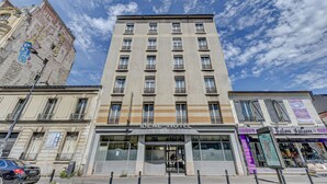 A multi-story hotel with a modern facade, large windows, and a visible entrance. - Hôtel Robespierre (Montreuil)